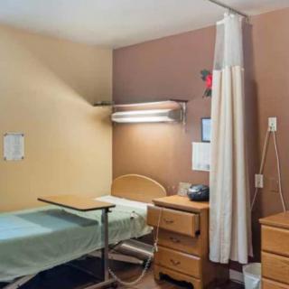 A hospital room featuring a bed, bedside table, and medical equipment.