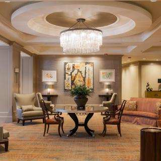 A luxurious hotel lobby with elegant furnishings and a grand chandelier.