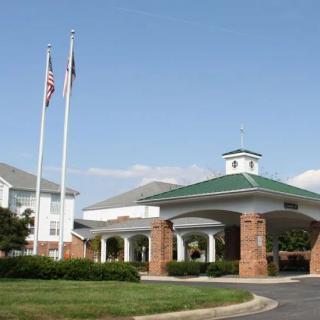 A building with a green-roofed entrance and flags flying outside.