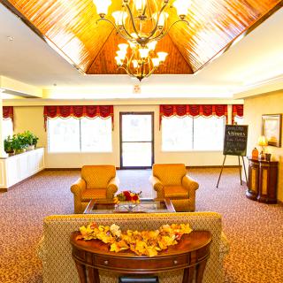 A warmly lit lobby with comfortable seating and a chandelier.