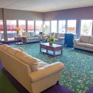 A bright lobby with comfortable sofas and a floral carpet.