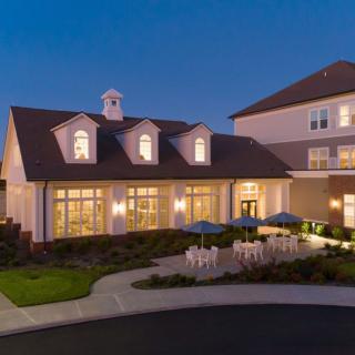 A well-lit building with a landscaped exterior in the evening.
