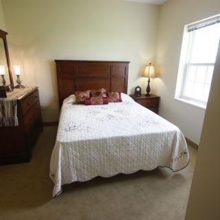 Cozy bedroom with wooden furniture and a large window.