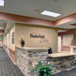 Reception area with a stone-accented desk and business signage.