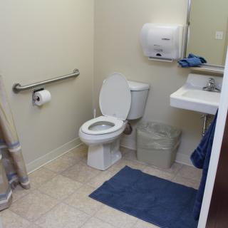 A clean and simple bathroom with a toilet, sink, and mirror.