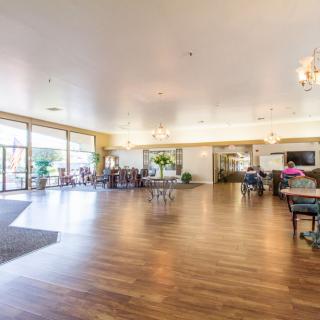 A spacious and bright lobby with hardwood floors and furniture.