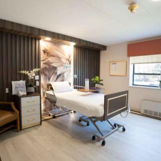 A modern hospital room with a single bed and stylish interior design.