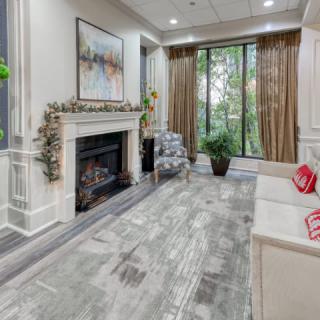 A modern living room with a fireplace, large windows, and stylish decor.