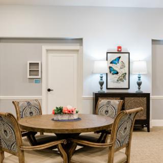 A cozy and elegantly designed living space featuring a wooden table, stylish chairs, and decorative elements.