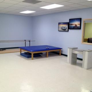 A physical therapy room with exercise equipment and minimalist design.