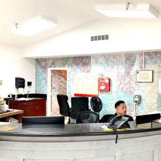 A reception area with a desk and computer in an office setting.