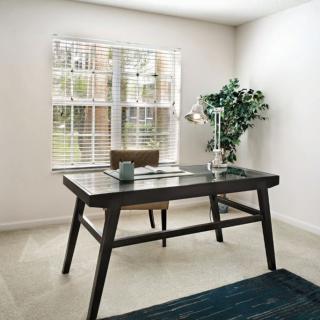 A modern, minimalist office space featuring a sleek desk, chair, and ample natural light.