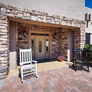 A charming entrance featuring rocking chairs and a stone facade.