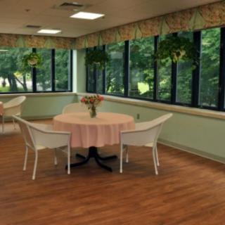 A cozy dining area with round tables and large windows overlooking greenery.