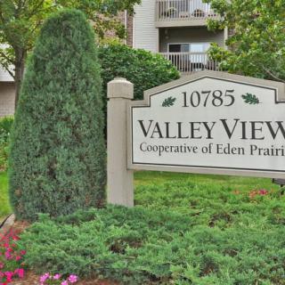 The entrance sign for Valley View Cooperative of Eden Prairie surrounded by lush greenery.