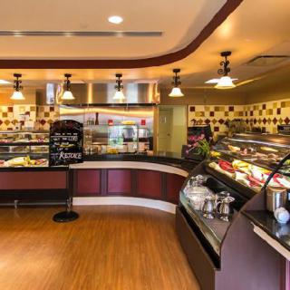 Interior of a cozy cafe with dessert display counters and warm lighting.