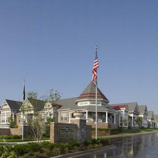 A scenic view of a large building with architectural details, featuring an American flag at the front.