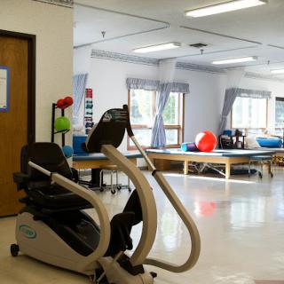 A well-equipped physical therapy room featuring exercise machines and rehabilitation tools.