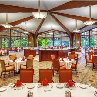 An elegant restaurant dining area with neatly set tables and red napkins.