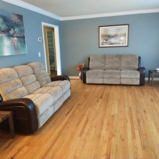 A cozy living room with blue walls and comfortable sofas on a hardwood floor.