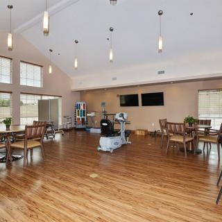 A spacious and modern dining area with hardwood floors, ample seating, large windows, and ceiling lights.