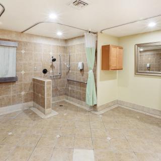Spacious bathroom with a walk-in shower and accessibility features.