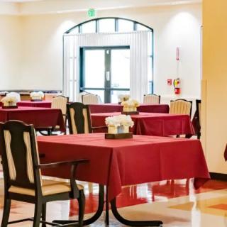 An empty restaurant dining area with tables and red tablecloths.