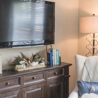 Cozy living room with a flat-screen TV, decorative cabinet, and comfortable seating.