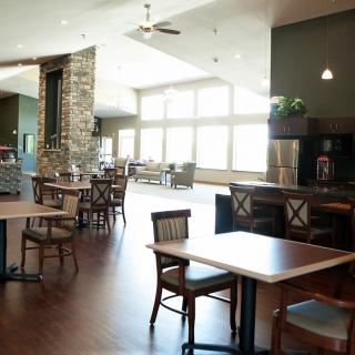 A spacious dining area with modern decor, featuring large windows that allow plenty of natural light.