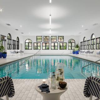 A luxurious indoor swimming pool with elegant design and comfortable seating areas.