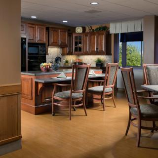 A modern kitchen and dining area featuring wood cabinets and a table with chairs.