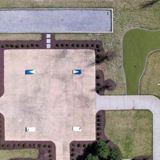 Aerial view of a parking lot with pathways and landscaped areas.