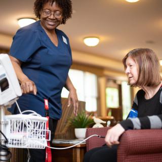 A nurse is using medical equipment to check the blood pressure of a patient.