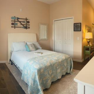 A cozy bedroom with soft lighting and a neatly arranged bed.