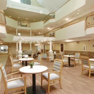 A modern interior seating area with tables, chairs, and natural lighting.