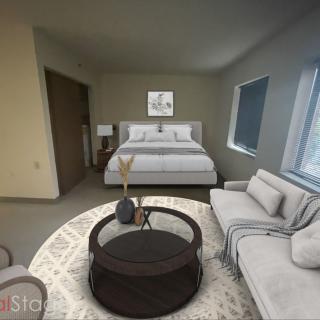 A modern bedroom with a cozy bed, sofa, and stylish coffee table.