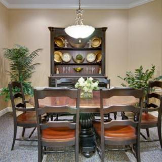 A cozy dining room with a wooden table and chairs, complemented by a decorative cabinet and soft lighting.