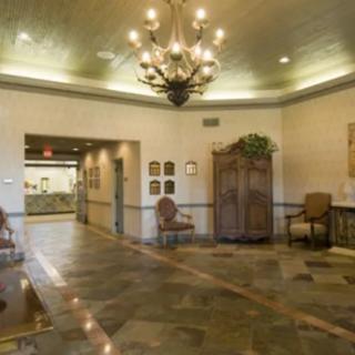 A well-lit lobby featuring a chandelier, comfortable seating, and decorative elements.