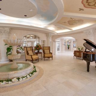 Luxurious interior with elegant decor, featuring a grand piano and indoor fountain.