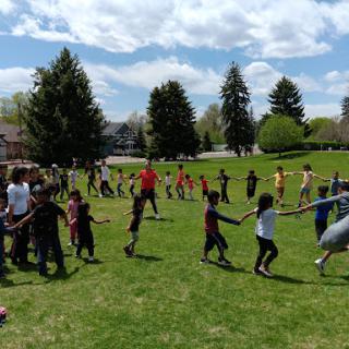 Children engaging in a group activity outside on a sunny day.