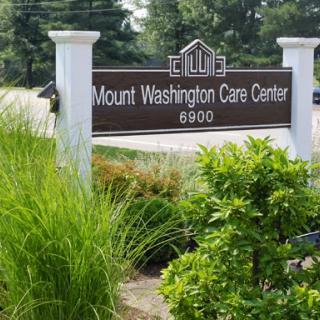 Signage for Mount Washington Care Center, surrounded by lush landscaping.