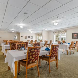 A spacious dining area with neatly arranged tables and chairs in a well-lit setting.