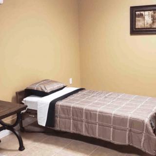 A minimalist bedroom with a single bed and simple decor.