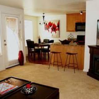 A cozy living space with an open layout connecting the kitchen and dining area, featuring modern decor.