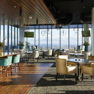 A modern restaurant interior with large windows offering a scenic view.