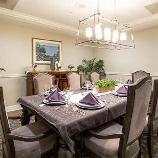 An elegantly set dining room table, complete with a chandelier and tasteful decor.