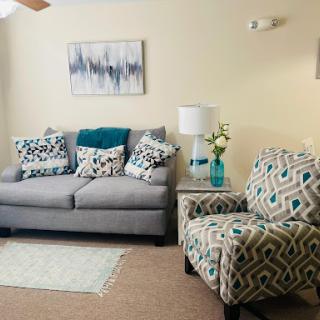 A cozy and modern living room featuring a stylish sofa, patterned armchair, and decorative elements.
