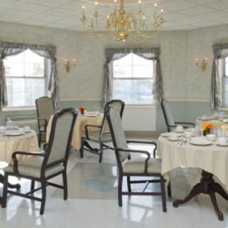 An elegant dining room with beautifully set tables and a chandelier.