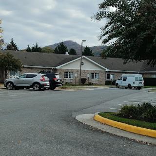 A peaceful residential area with a parking lot and overcast skies.