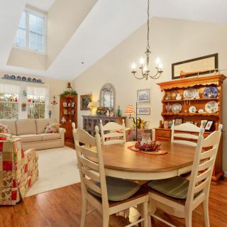 A cozy dining and living area featuring a wooden table and chairs, a comfortable sofa, and elegant interior decor.
